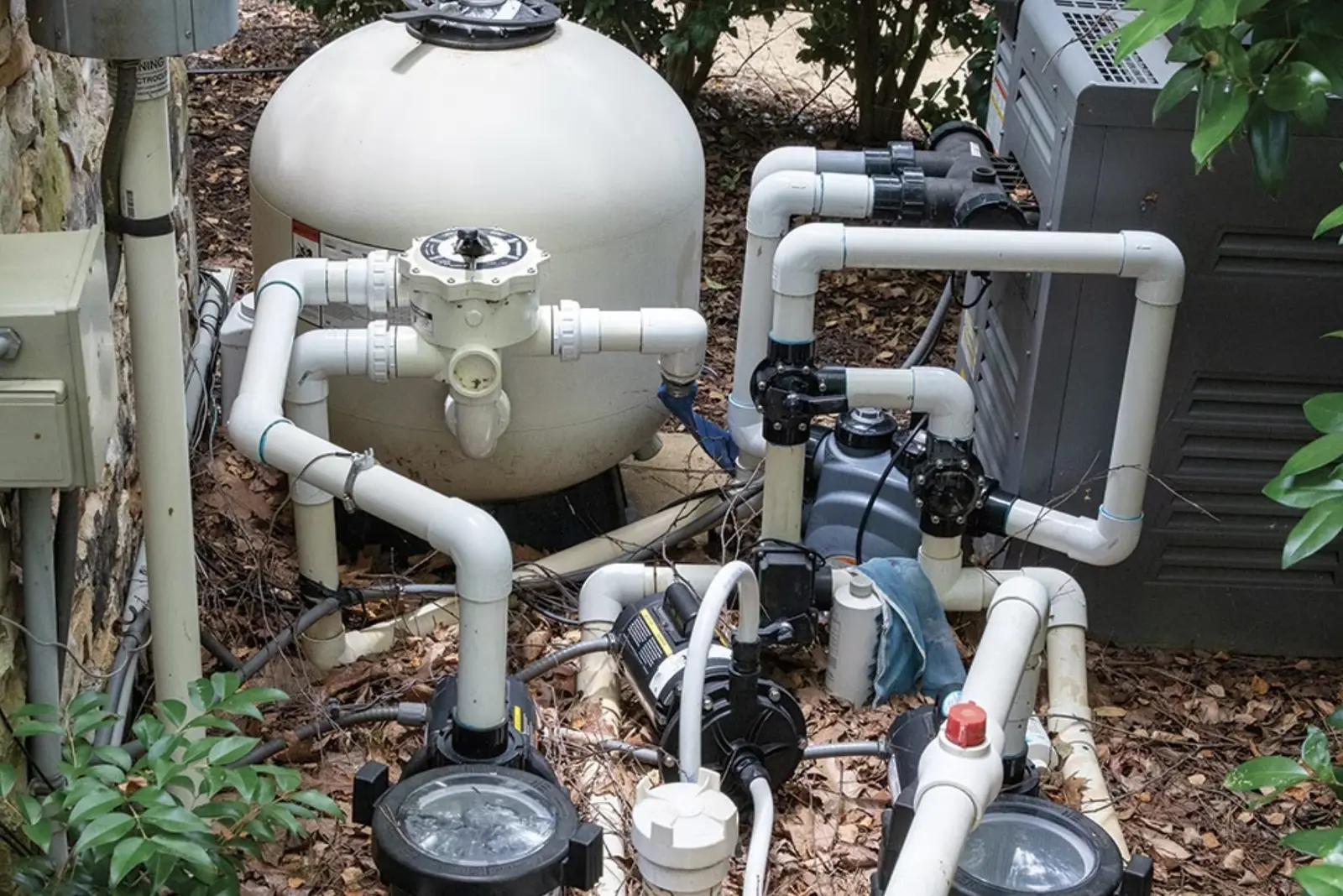 Pool filtration system with sand filter and pump equipment surrounded by mulch and landscaping - Cox Pool Services & Repair, Clovis, CA
