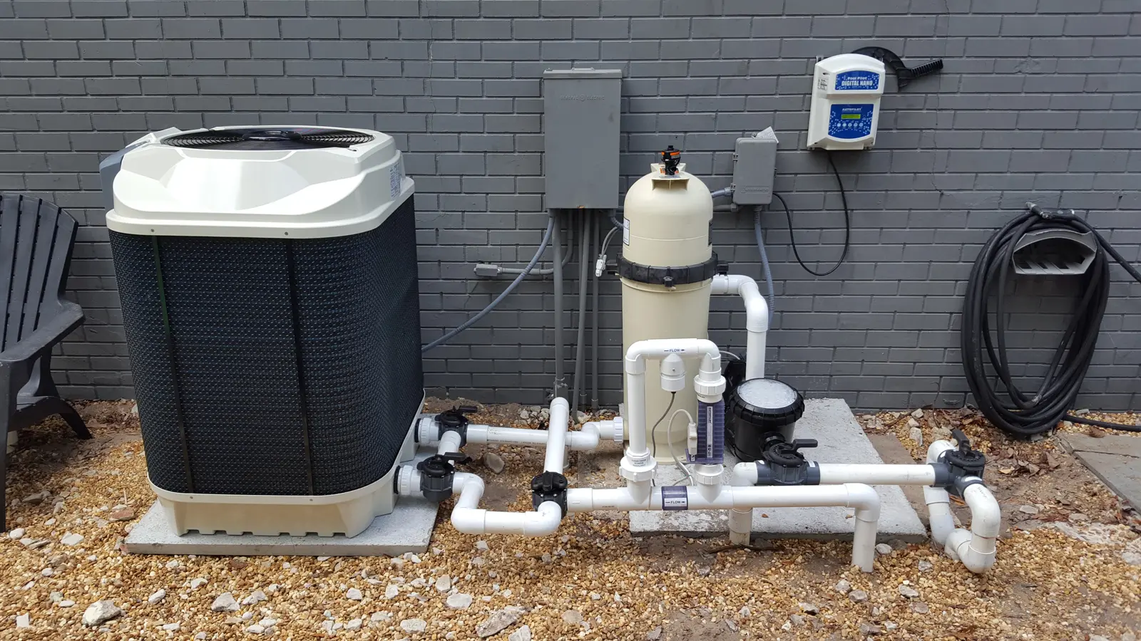 Professional pool equipment installation with heat pump, filter, and automation controls mounted on brick wall - North East Florida Pool Service, Jacksonville, FL