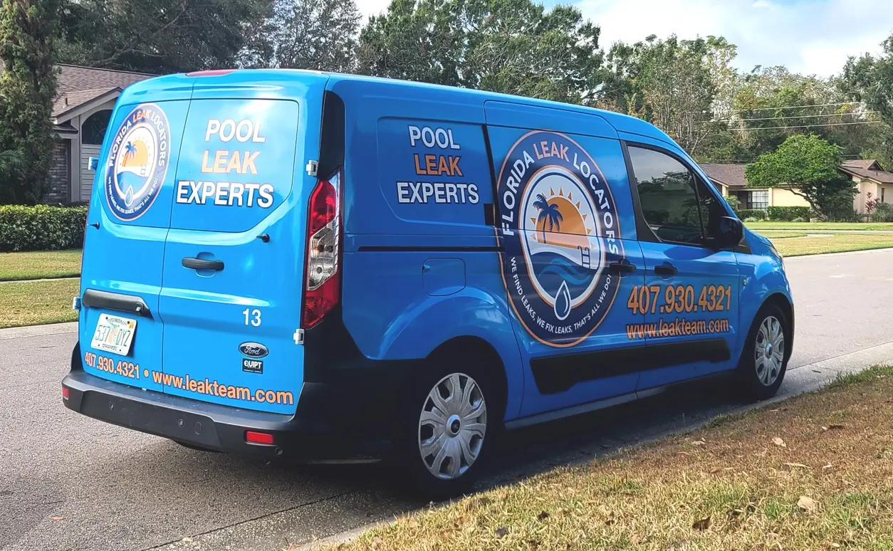 Bright blue Florida Leak Locators service van with logo and contact details parked on residential street - Florida Leak Locators, Orlando, FL