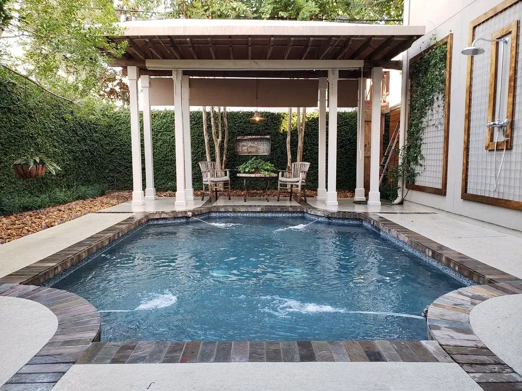 Sparkling clean backyard pool with brick edging, pergola, and patio furniture - Sweetwater Pool & Patio, Bellaire, TX