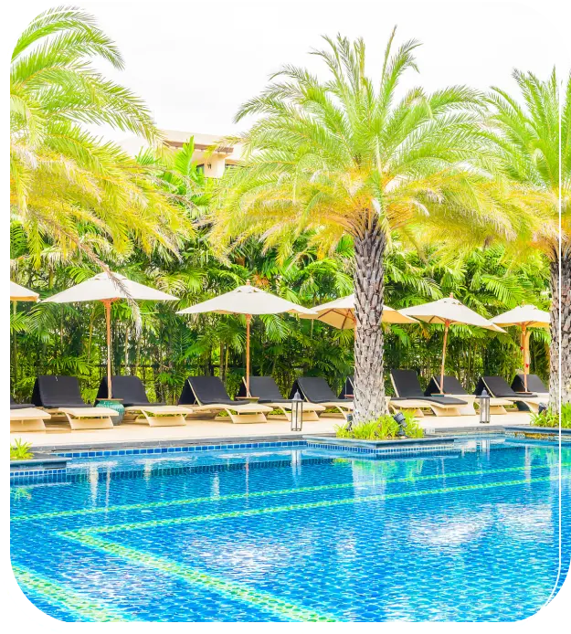 Sparkling blue resort pool with lounge chairs, umbrellas, and palm trees - Brad’s Pool Service, Corpus Christi, TX