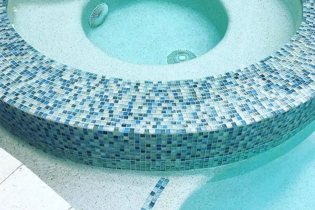 Overhead view of a clean spa with blue mosaic tile surround and clear turquoise water - Manning Pool Service, Houston, TX