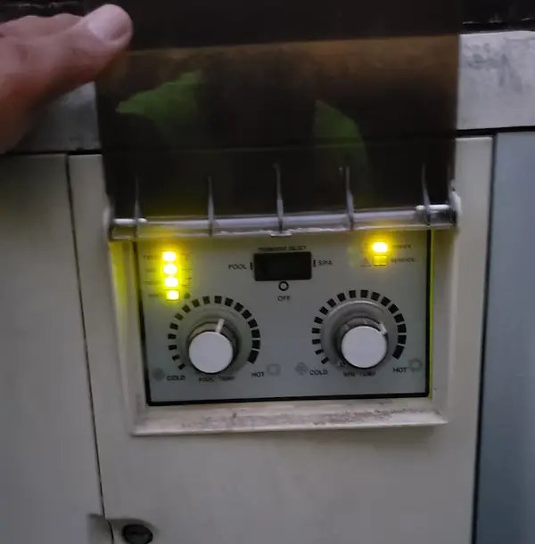 Close-up of a pool/spa control panel with yellow indicator lights and two dials - Pro-Tech Pool Services, San Antonio, TX