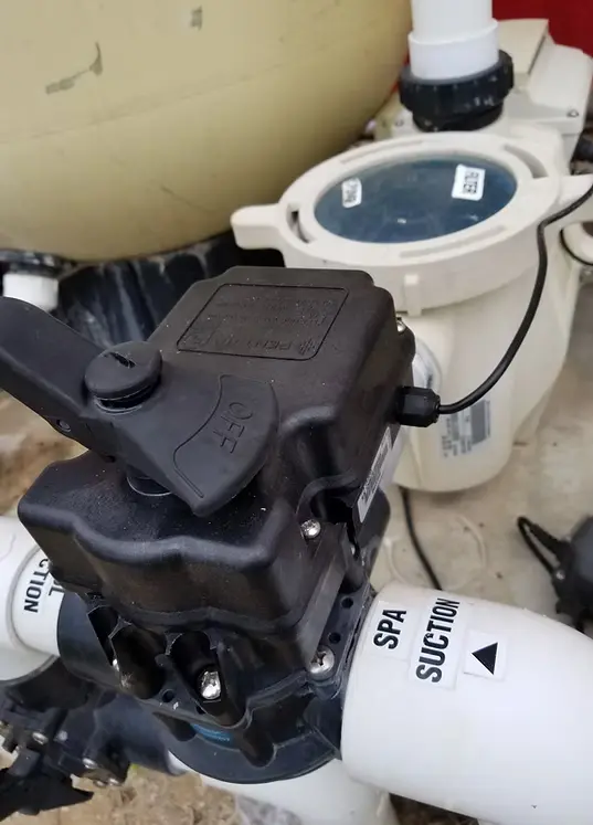 Pool filtration and circulation equipment including black multiport valve and white tanks on floor - Pro-Tech Pool Services, San Antonio, TX